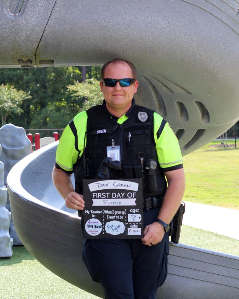 School Resource Officer Green in front of a playground slide