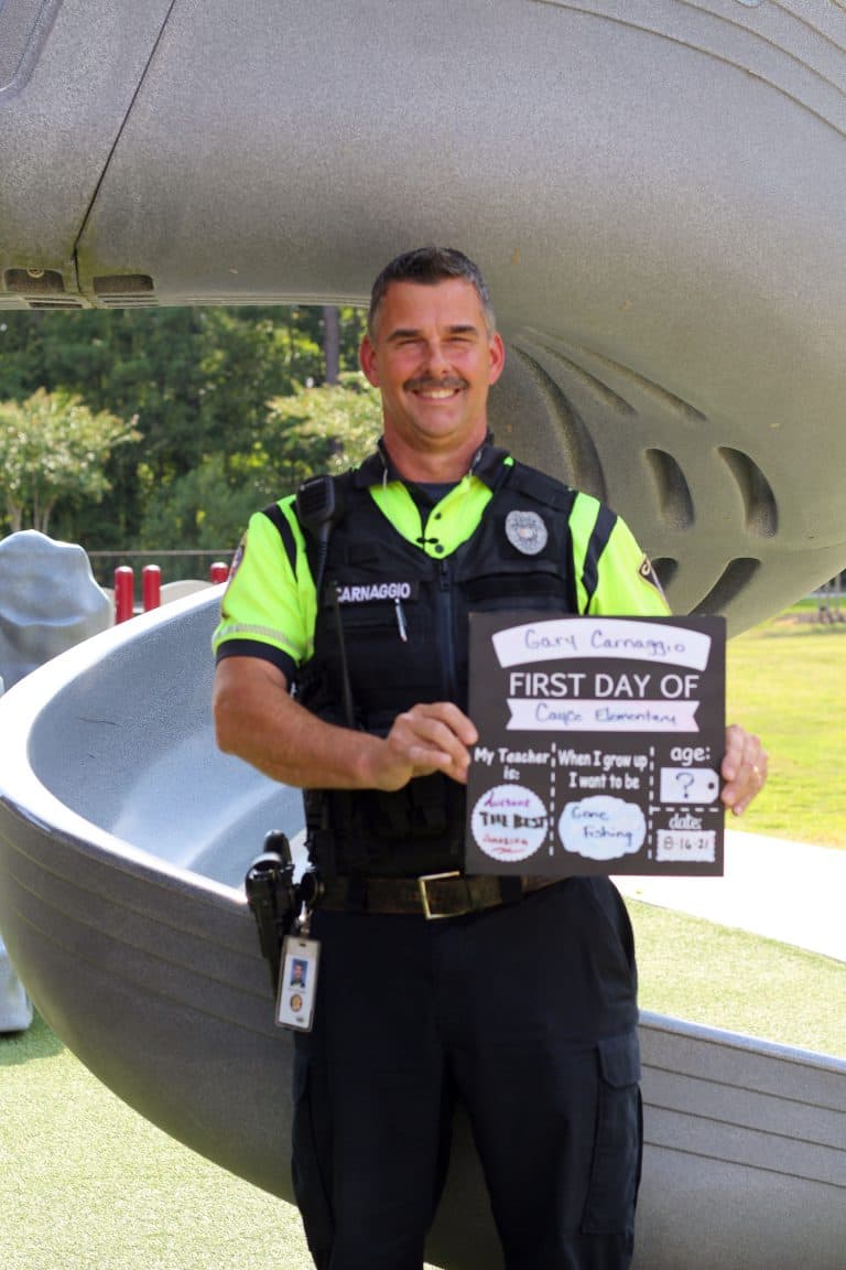 School Resource Officer Carnaggio in front of a playground slide