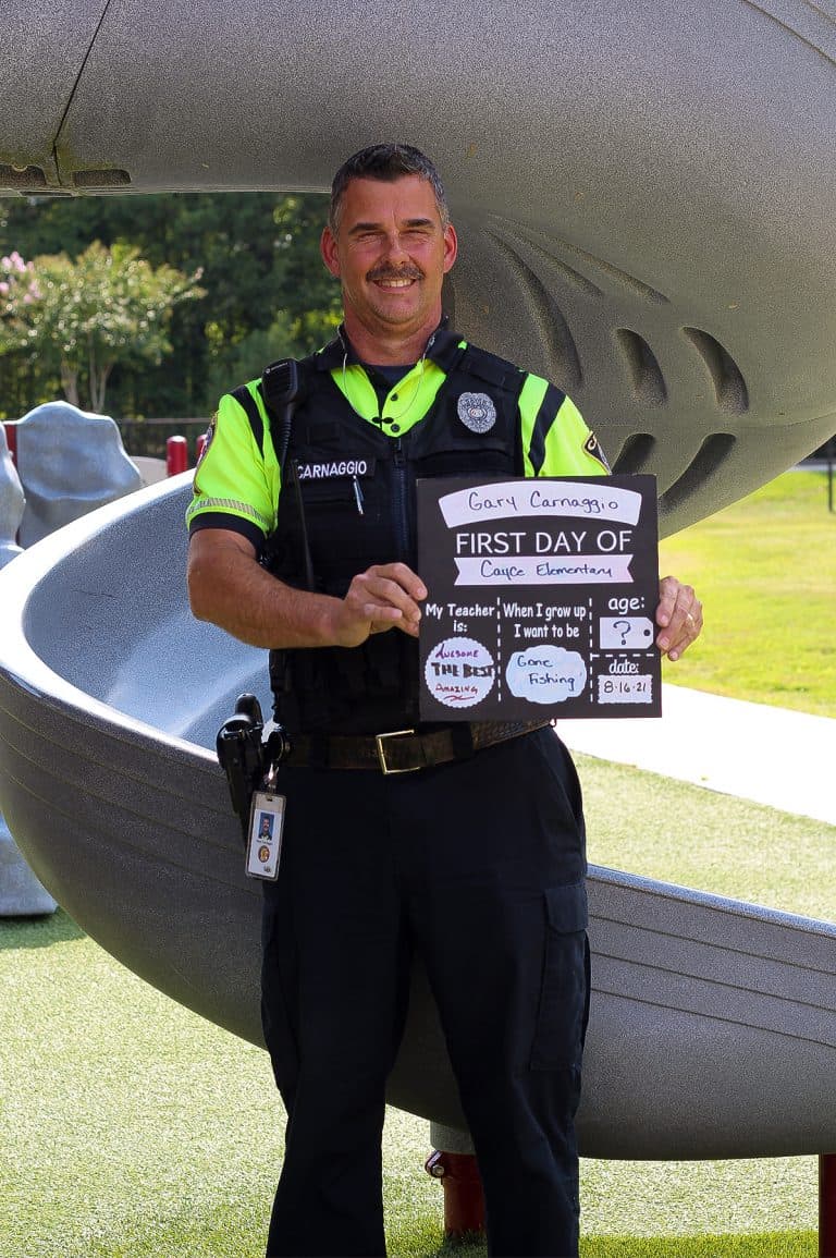 School Resource Officer Carnaggio in front of a playground slide